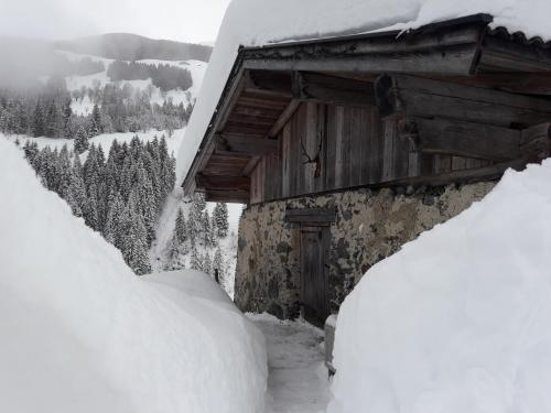 a snow covered cabin with a pile of snow at Chalet Ursteinhütte in Kelchsau