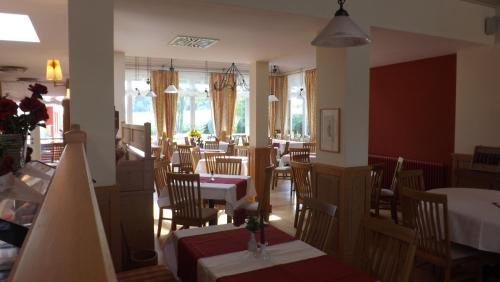 une salle à manger avec des tables et des chaises dans un restaurant dans l'établissement Schwarzwald Lodge Rothaus, à Grafenhausen