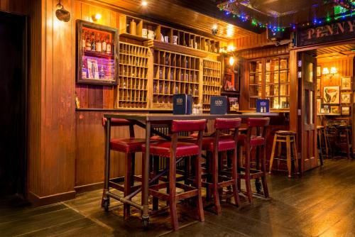 a bar with red bar stools in a pub at The Residence Hotel in Galway