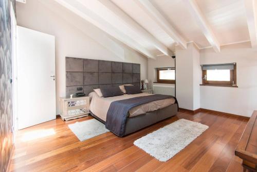 una camera con un grande letto e pavimenti in legno di Luxury Tuscan House a Pietrasanta