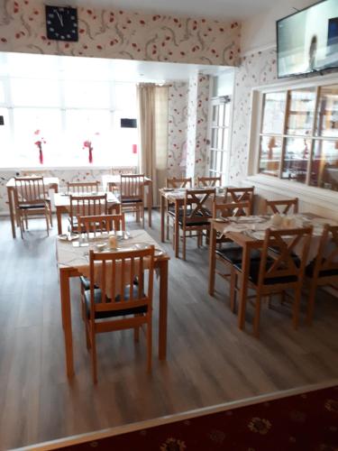 a restaurant with wooden tables and chairs in a room at Montgomery Hotel in Blackpool