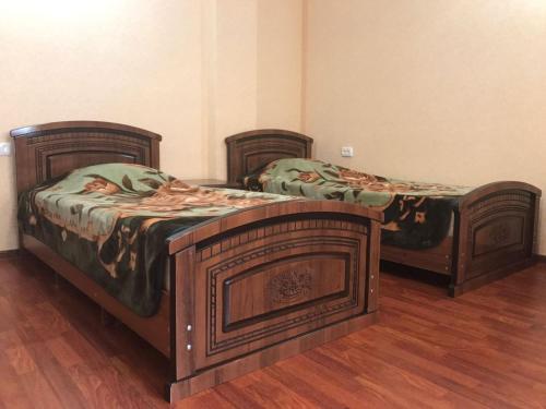 キスロヴォツクにある2-ух комнатная квартира в центре городаのウッドフロアの客室で、ツインベッド2台が備わります。