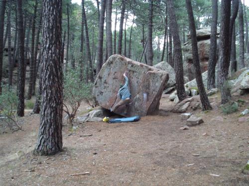 a person hugging a large rock in the woods at Camping-Bungalows Ciudad de Albarracín in Albarracín