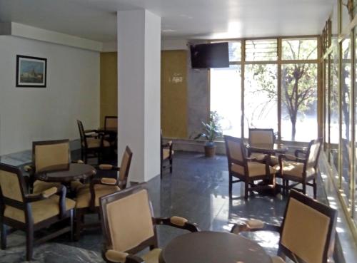 a restaurant with tables and chairs and a large window at Residencias Señorial in Mexico City