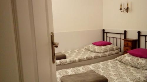 2 camas en una habitación con almohadas rosas en Apartament MARIA, en Gdansk