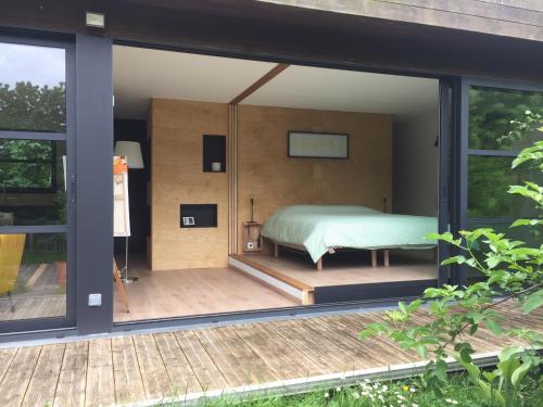 a room with a bed on a patio at La Tête Dans Les Étoiles in Boeschèpe