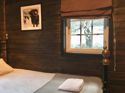 um quarto com uma cama e uma janela em Bjørkum Gard em Ljøsne