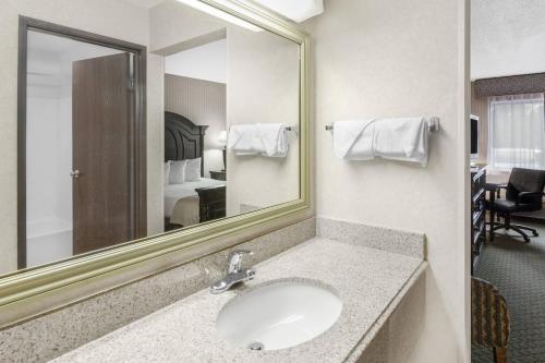 a bathroom with a sink and a mirror at Baymont by Wyndham Bridgeport/Frankenmuth in Bridgeport