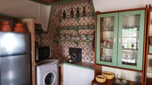 a kitchen with a refrigerator and a washing machine at Casa dos Felicias in São Roque do Pico