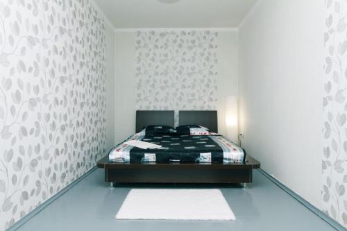 ein Schlafzimmer mit einem Bett und einer weißen Wand in der Unterkunft Донца 20 2-х ком апартаменты Шалимова, Исида, НАУ, Лепсе, Отрадный, аэропорт Жуляны in Kiew