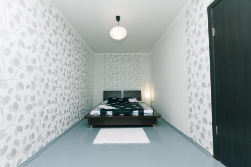ein Schlafzimmer mit einem Bett und einer weißen Wand in der Unterkunft Донца 20 2-х ком апартаменты Шалимова, Исида, НАУ, Лепсе, Отрадный, аэропорт Жуляны in Kiew