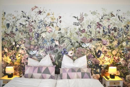 a bedroom with a floral wall mural next to a bed at Ferienwohnung Alexander in Weimar