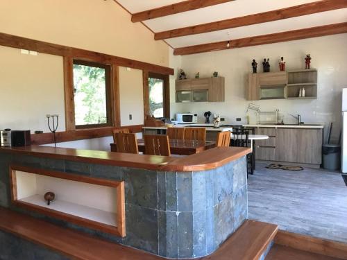 a large kitchen with a large island in a room at Cabañas JL in Las Trancas