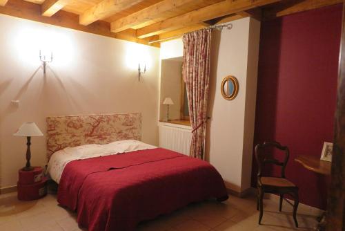 a bedroom with a bed with a red blanket at "Au Saint-Jean in Belley