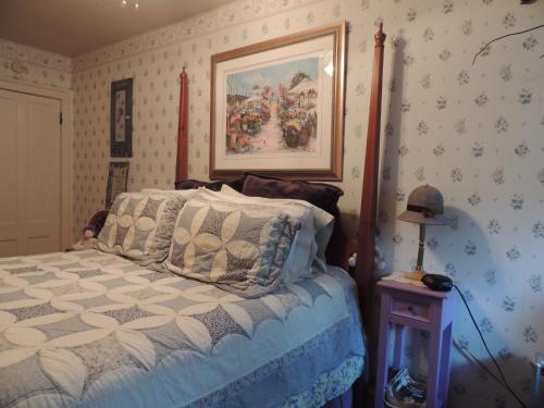 a bedroom with a bed and a picture on the wall at Brookview Manor Inn in Canadensis