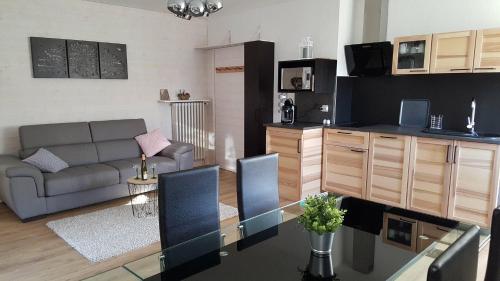 un salon avec un canapé et une table dans l'établissement Au Petit Bonheur Charmant Gite Colmar, à Horbourg-Wihr