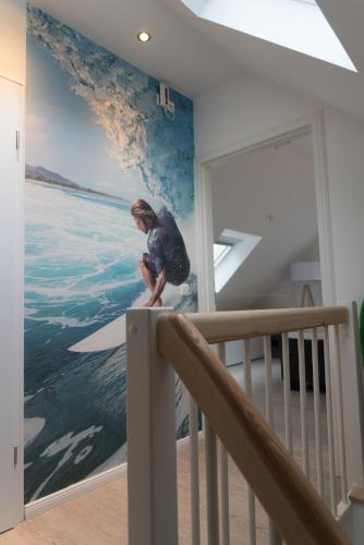 a person riding a wave on a surfboard in a room at Hotel Stadt Cuxhaven in Cuxhaven