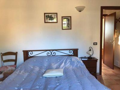 Pieve di Santa LuceにあるPalazzo Residence Giuli Rosselminiのベッドルーム1室(青いベッド1台、青い掛け布団付)