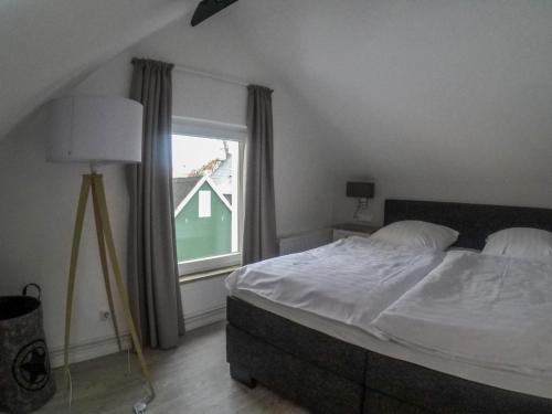a bedroom with a large bed and a window at Hotel Stadt Cuxhaven in Cuxhaven