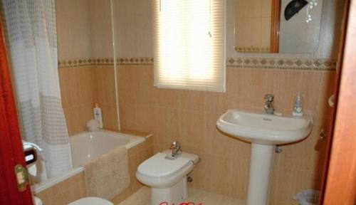 W łazience znajduje się umywalka, toaleta i wanna. w obiekcie One-bedroom flat 200m from the beach w mieście Almería