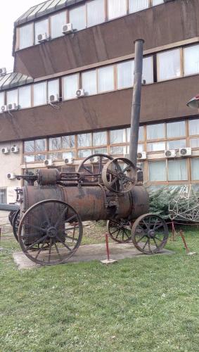 an old steam engine on display in front of a building at Stan na dan Banja Luka in Banja Luka