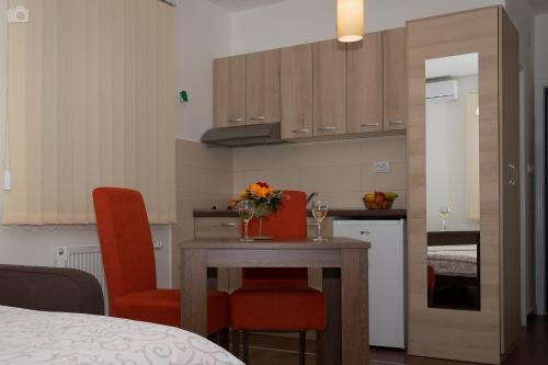 a kitchen with a table and two chairs and a kitchen with a table at Sobe i apartmani Kety in Kragujevac