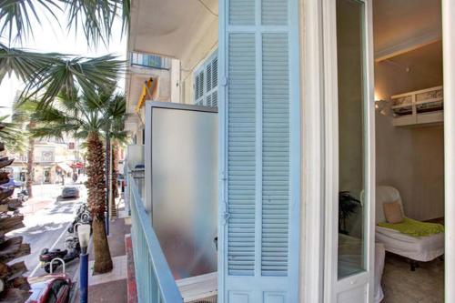 アンティーブにあるStudio- Antibes-Juan les Pins- Cote d'Azurの青い扉とヤシの木のある家