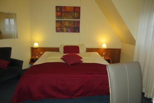 a bedroom with a large bed with a red blanket at Burghotel Münzenberg in Münzenberg