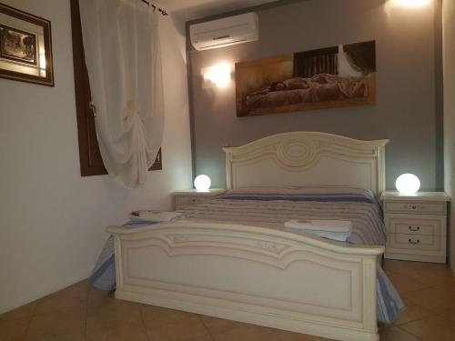a bedroom with a white bed and two night stands at B&B Martina in Agugliaro