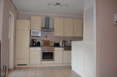 a small kitchen with white cabinets and appliances at FH Bernstein in Ostseebad Karlshagen