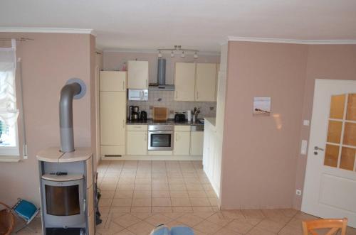 a kitchen with white cabinets and a tile floor at FH Bernstein in Ostseebad Karlshagen