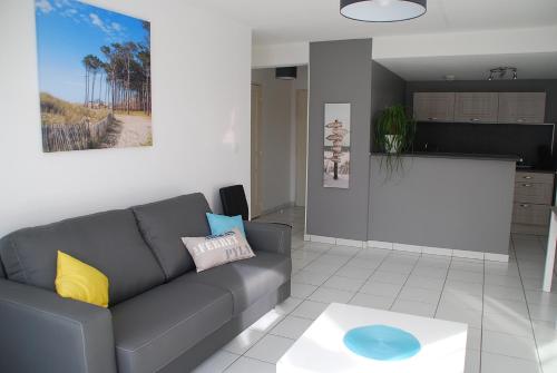 un salon avec un canapé et une cuisine dans l'établissement Comme à la maison, à Gujan-Mestras