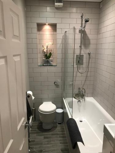 a bathroom with a tub and a toilet and a sink at Boutique City Centre 1 Bed Apartment in Edinburgh