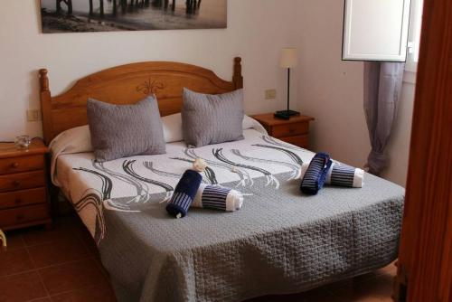 a bed with two pillows and a teddy bear on it at Casa Armando in Caleta de Sebo