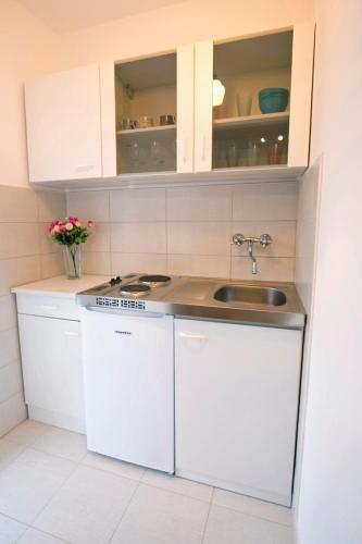 a kitchen with white cabinets and a sink at Corner Of Joy in Vis