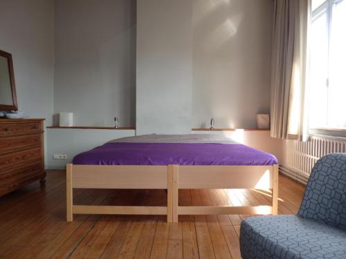 a bedroom with a purple bed and a chair at W'allons nous dormir in Liège