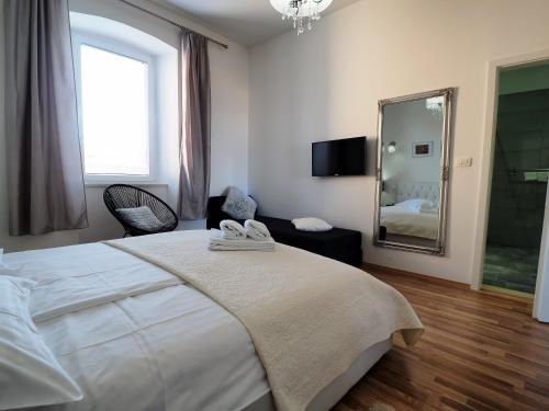 a bedroom with a large white bed and a mirror at Captain Emo City Apartments in Pula