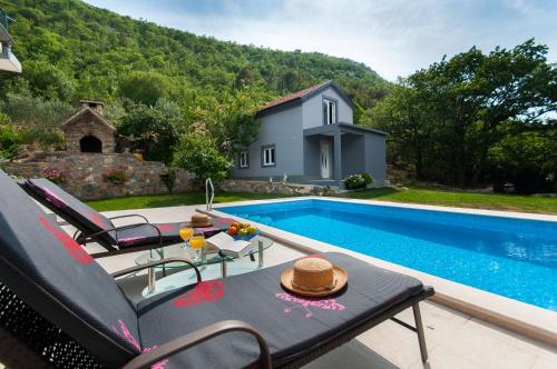une villa avec une piscine et une maison dans l'établissement Apartments Srdanovic, à Omiš