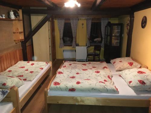 two twin beds in a room with a room with two windows at Medvědí boudy in Loučná pod Klínovcem