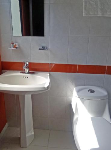 a white bathroom with a sink and a toilet at Residencias Señorial in Mexico City