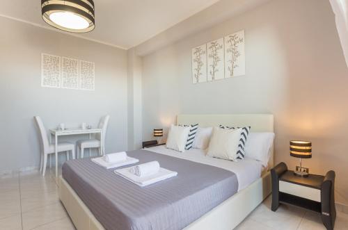 a white bedroom with a bed and a table at Residenze Su Planu in Cagliari