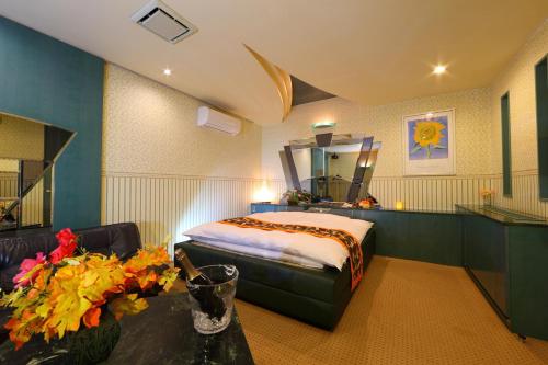 a bedroom with a bed and a mirror and a table at Hotel La Siena (Adult Only) in Higashi-osaka