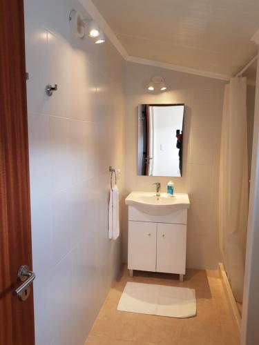 a bathroom with a white sink and a shower at Páteo Badajoz in Sintra