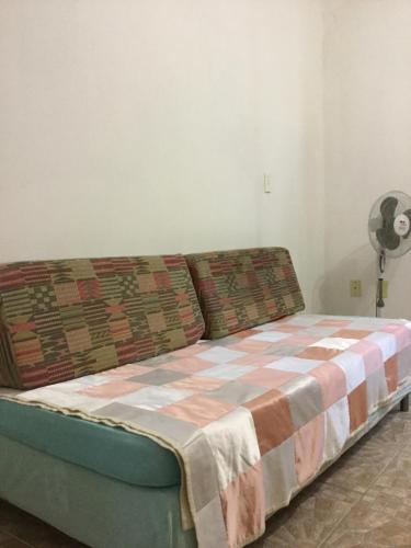 Una cama con una manta en una habitación en Venha para Florianópolis, en Florianópolis