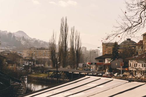 a view of a city with a river and buildings at Hotel Nova Bentbaša in Sarajevo