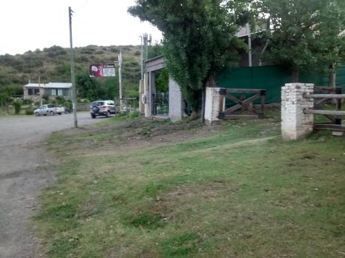 a building on the side of a road next to a field at Casa de montaña, valle del sol, potrerillos, Mendoza in Mendoza