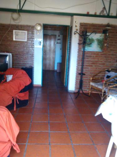 a room with a red tile floor and a room with beds at Casa de montaña, valle del sol, potrerillos, Mendoza in Mendoza