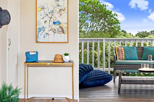 a balcony with a table and a blue chair at Southern Belle Mollymook in Mollymook