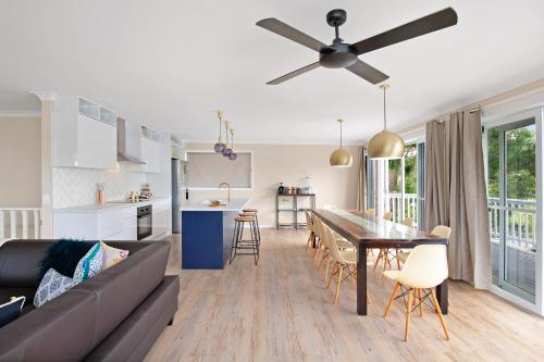 a living room and kitchen with a couch and a table at Southern Belle Mollymook in Mollymook
