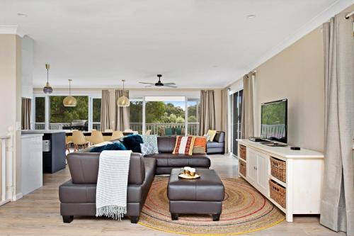 a living room with a couch and a table at Southern Belle Mollymook in Mollymook
